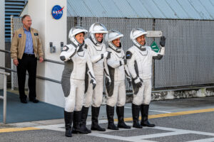 Crew-5 Astronauts waving at cameras outside of the Neil Armstrong Operations and Checkout Building.